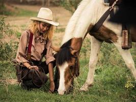 cowgirl e o cavalo estão profundamente ligados um ao outro no amor por causa de seus relacionamentos angustiados em um bandido selvagem foto