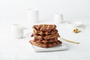 waffles de banana chocolate na mesa branca. estilo minimalista escandinavo, vista lateral
