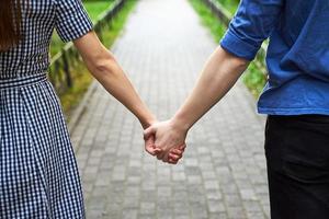 closeup de casal apaixonado de mãos dadas enquanto caminhava no parque
