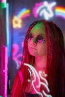 menina em luzes de neon, mulher bonita em óculos de sol, com cabelo rosa, com tranças dreadlocks foto