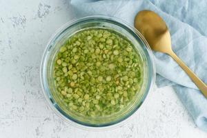 embebendo cereais de ervilhas verdes em água para fermentar cereais e neutralizar o ácido fítico. foto