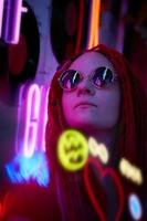 menina em luzes de neon, mulher bonita em óculos de sol, com cabelo rosa, com tranças dreadlocks foto