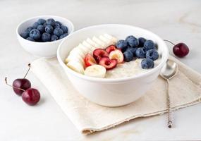 tigela grande de aveia saborosa e saudável com frutas e bagas no café da manhã, refeição matinal. foto