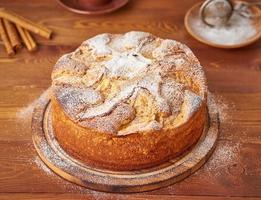 bolo francês de maçã com maçãs, canela na mesa da cozinha de madeira escura, vista lateral foto