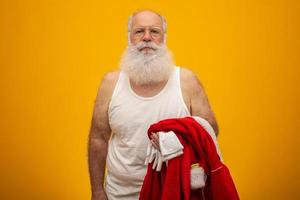 papai noel segurando suas roupas depois ou antes de entregar os presentes. roupas de papai noel. traje. foto