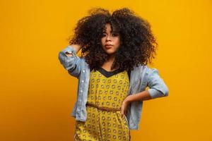 retrato da beleza da mulher afro-americana com penteado afro e maquiagem glamour. mulher brasileira. mestiço. cabelo encaracolado. Penteado. fundo amarelo. foto