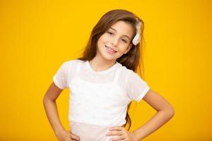 retrato de uma menina criança sorridente feliz em fundo amarelo. foto