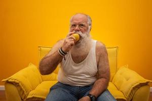 retrato de um homem barbudo prestes a comer uma maçã. sênior com uma maçã. foto