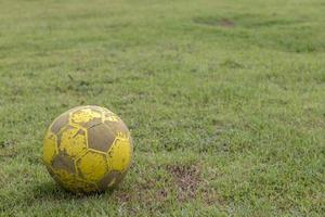 futebol amarelo velho no gramado. foto