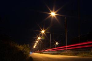 acenda a lâmpada com os faróis na estrada no escuro. foto