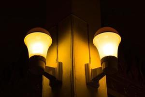 lâmpada amarela com poste em quarto escuro. foto