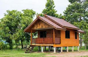 pequena casa de madeira em estilo tailandês, perto de muitas árvores. foto