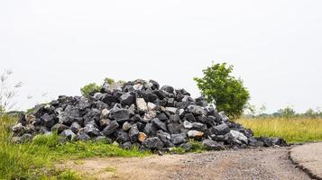 pilha de granito ao lado da estrada rural. foto