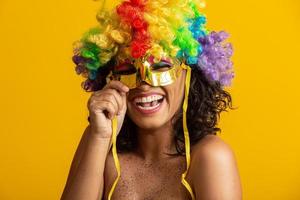 linda mulher vestida para a noite de carnaval. mulher sorridente pronta para curtir o carnaval com uma peruca colorida e máscara