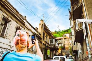 tbilisi, geórgia - 30 de abril de 2022 - turista tira foto de edifícios antigos da cidade na rua da capital da geórgia