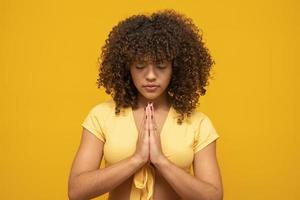 sorridente jovem pacífica praticando ioga e meditação. mulher calma fazendo gesto de namastê e olhando para a câmera. conceito de ioga. gratidão. foto