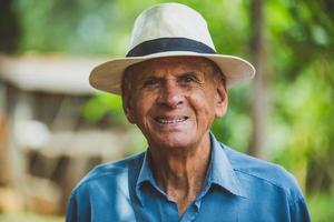 retrato de sorrindo lindo agricultor masculino mais velho. homem idoso na fazenda em dia de verão. atividade de jardinagem. homem idoso brasileiro. foto