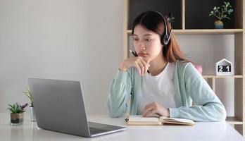 mulher asiática estudante videoconferência e-learning com professor no computador na sala de estar em casa. e-learning, online, educação e distanciamento social na internet protegem contra vírus covid-19. foto