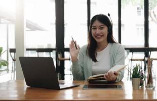 mulher asiática usando fones de ouvido estuda on-line assistindo podcast de webinar no laptop ouvindo chamada de conferência de curso de educação de aprendizagem, conceito de elearning.