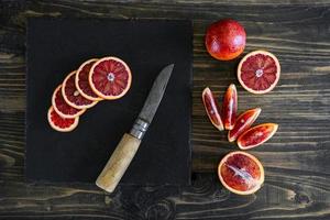 fatias de laranjas sicilianas ou sangrentas em um fundo de ardósia preta foto
