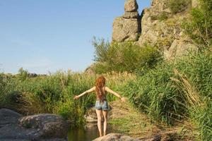 jovem mulher bonita com dreadlocks nadar no rio da montanha no verão, mulher ruiva na lagoa foto