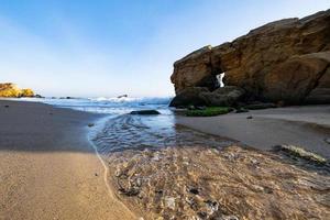 bela paisagem com pôr do sol, falésias e mar foto