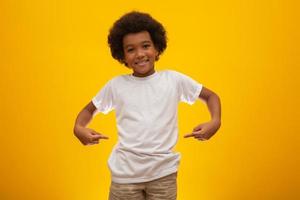 menino afro-americano com cabelo black power sobre fundo amarelo. sorridente garoto negro com um cabelo black power. menino negro com um cabelo black power. Descendência africana. foto