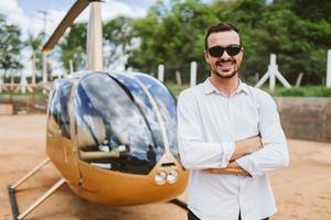 piloto de helicóptero particular. piloto perto de helicóptero. homem latino. foto