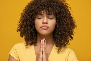 sorridente jovem pacífica praticando ioga e meditação. mulher calma fazendo gesto de namastê e olhando para a câmera. conceito de ioga. gratidão. foto