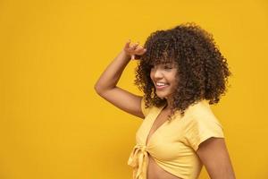 linda modelo morena sorrindo e vendo ao lado. belos dentes. cabelo encaracolado. jovem brasileira. foto