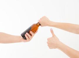 mão pega uma garrafa de cerveja e mostra como isolado no fundo branco. copie o espaço