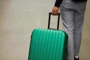 esperando no aeroporto. o conceito de férias de verão, um viajante com uma mala na área de espera do terminal do aeroporto. foco seletivo. foto
