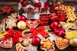 brinquedos de natal e biscoitos doces na mesa de madeira. vista superior e foco seletivo. feliz ano novo conceito foto