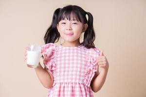 imagem de criança asiática bebendo leite no fundo foto