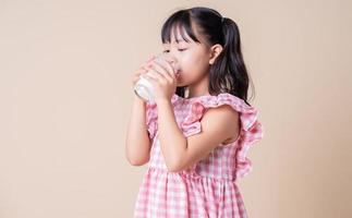 imagem de criança asiática bebendo leite no fundo foto
