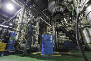 os trabalhadores do sexo masculino fazem a inspeção e registram o medidor de pressão do processo nas instalações do tanque do equipamento na graxa química vertical. foto