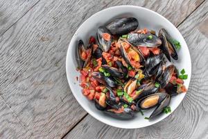 Prato de marisco mediterrâneo cozido no vapor de mexilhões com tomate e cebolinha foto