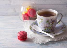 macarons franceses com uma xícara de chá foto