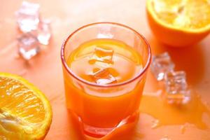 vista superior de um copo de suco de laranja com gelo foto