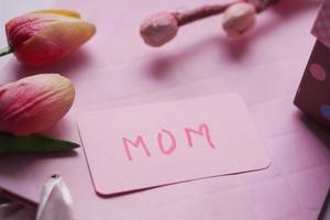 f presente de dia das mães e flores na mesa. foto