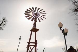 velha turbina eólica com lâminas no fundo do céu nublado foto