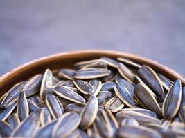 sementes de girassol em tigela de madeira com foco seletivo foto