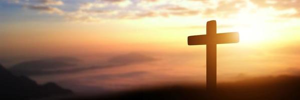silhueta da cruz católica ao fundo do sol. imagem panorâmica
