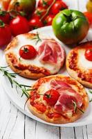 mini pizza com mussarela, presunto e tomate foto