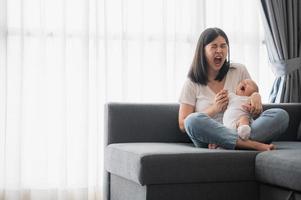 bebê boceja nos braços de sua mãe foto