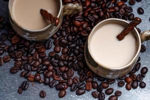 duas canecas de café com grãos de café em um pano de fundo escuro. foto