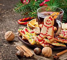 aquecimento de vinho quente, especiarias e biscoito de gengibre em um fundo de madeira em estilo rústico foto