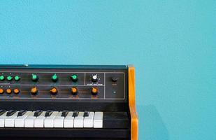 sintetizador antigo com interruptores coloridos em fundo azul foto