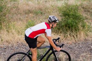 ciclista no treinamento de bicicleta de ciclocross ao ar livre na estrada de cascalho foto