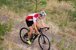 ciclista no treinamento de bicicleta de ciclocross ao ar livre na estrada de cascalho foto